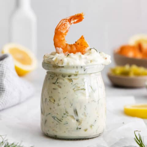 A jar of tartar sauce with a shrimp on top