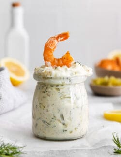 A jar of tartar sauce with a shrimp on top