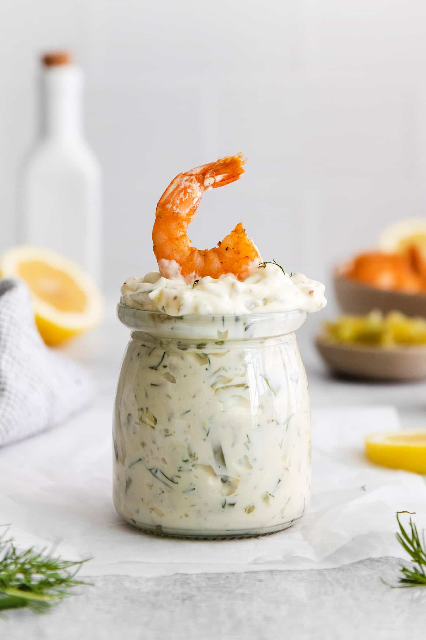 A jar of tartar sauce with a shrimp on top