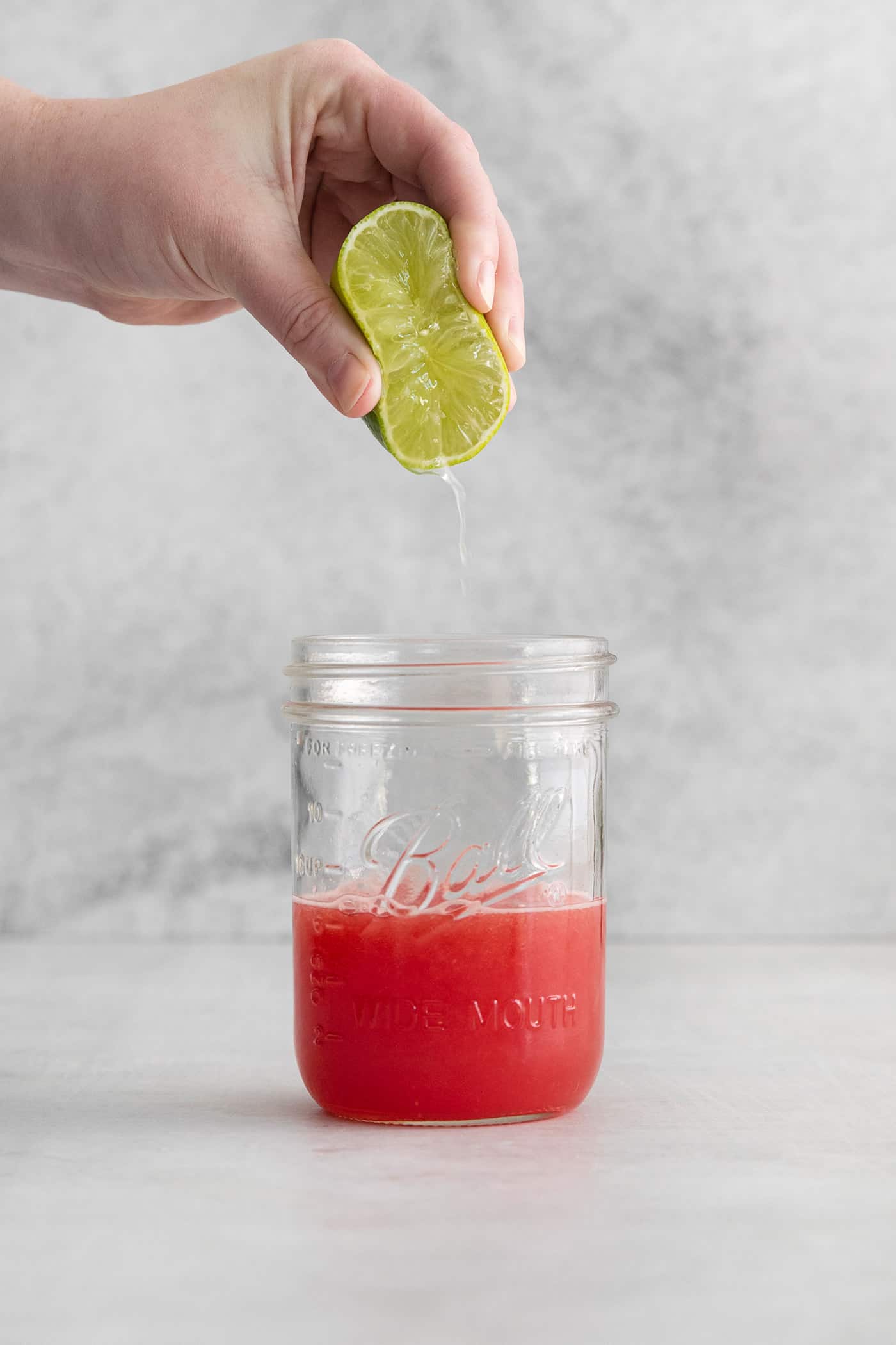 squeezing lime into a jar