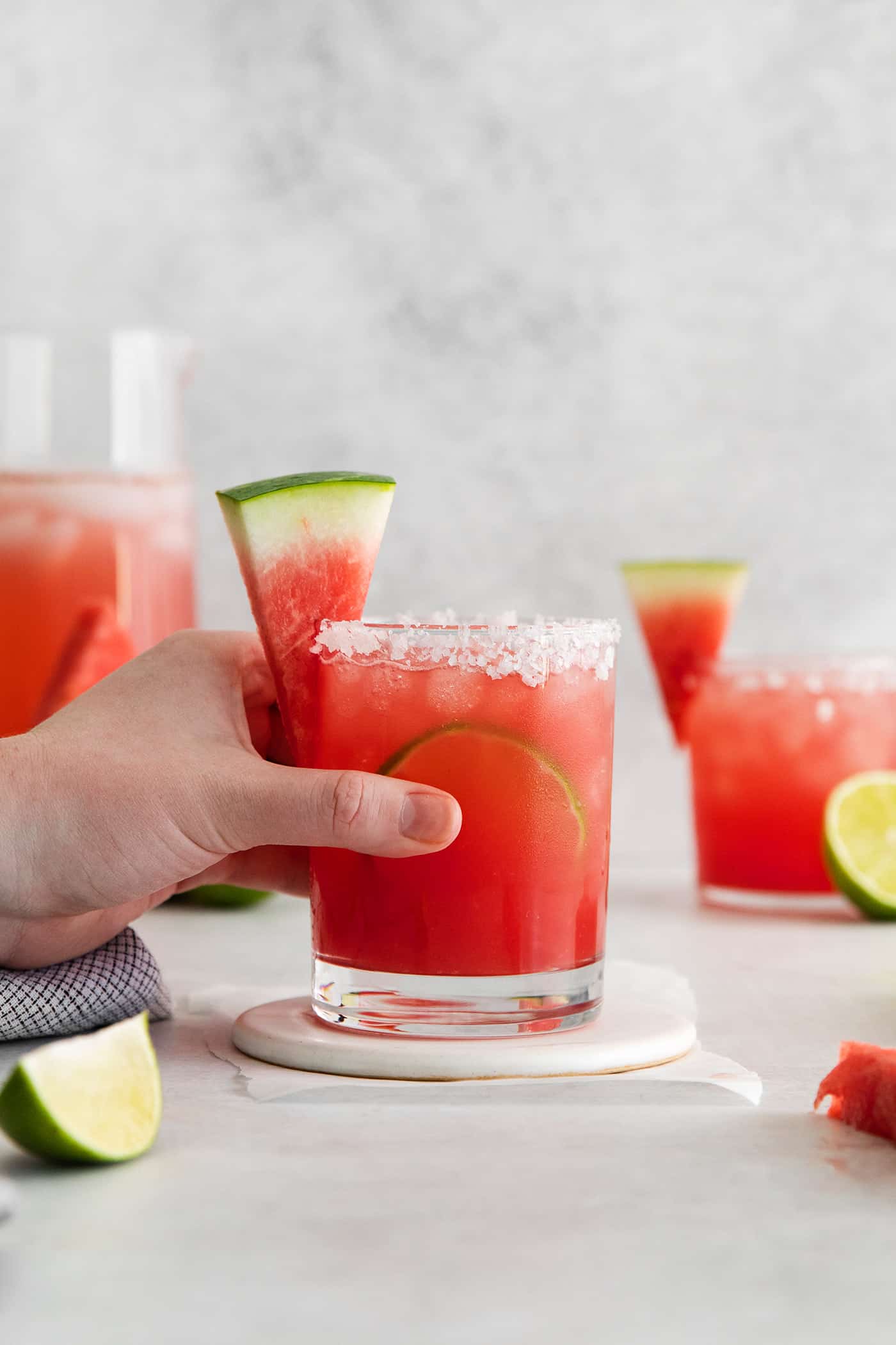 hand holding a margarita made with fresh watermelon juice