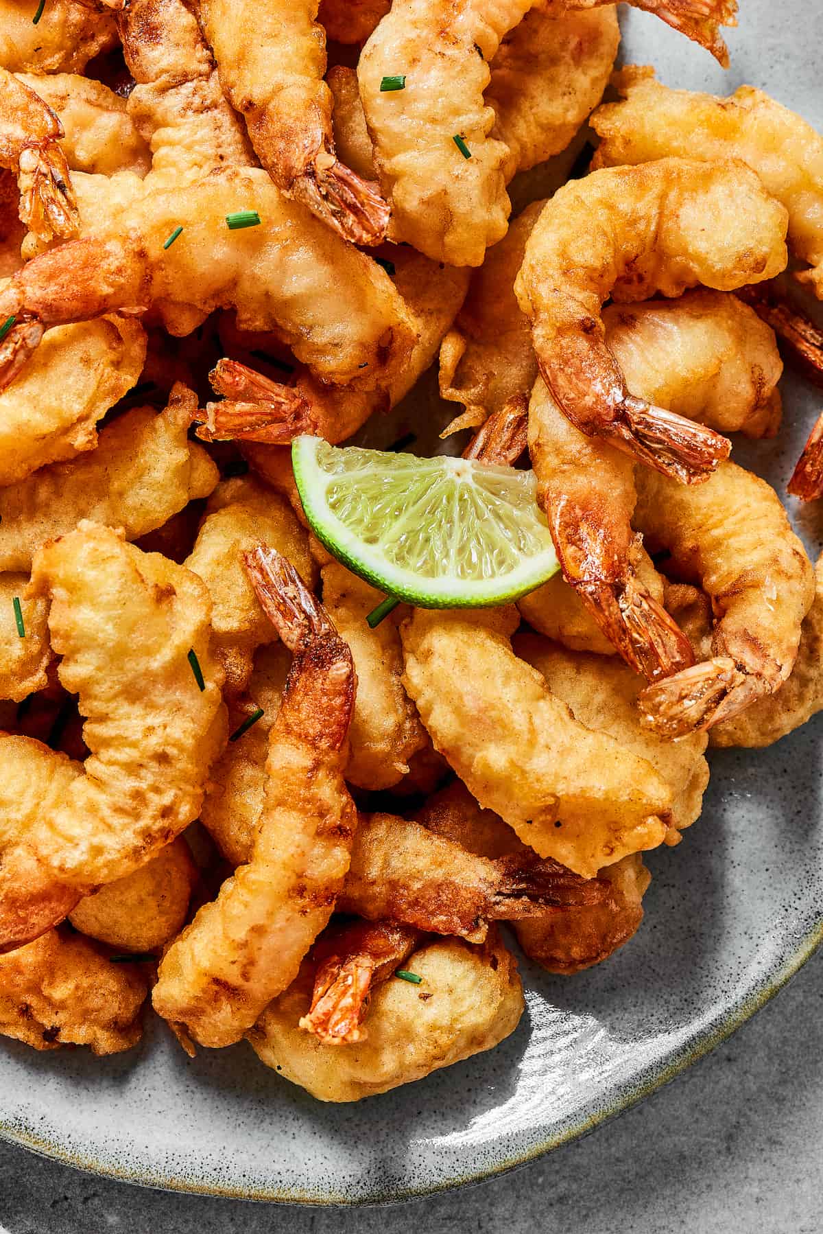 A plate of shrimp tempura with a lime wedge