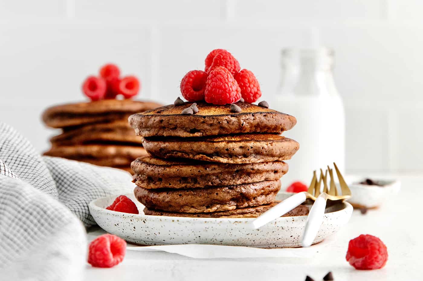 A stack of chocolate pancakes on a white plate