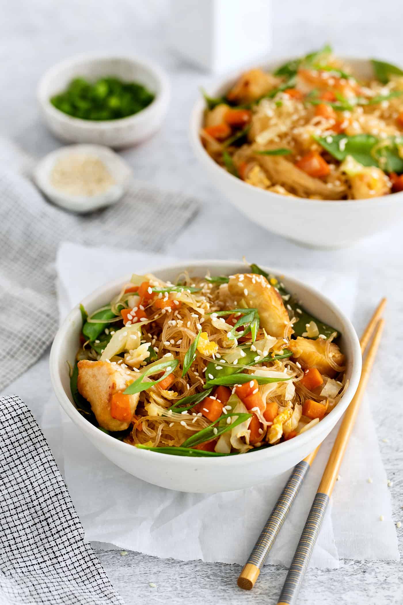 Angled view of a bowl of Thai glass noodle stir fry with chicken