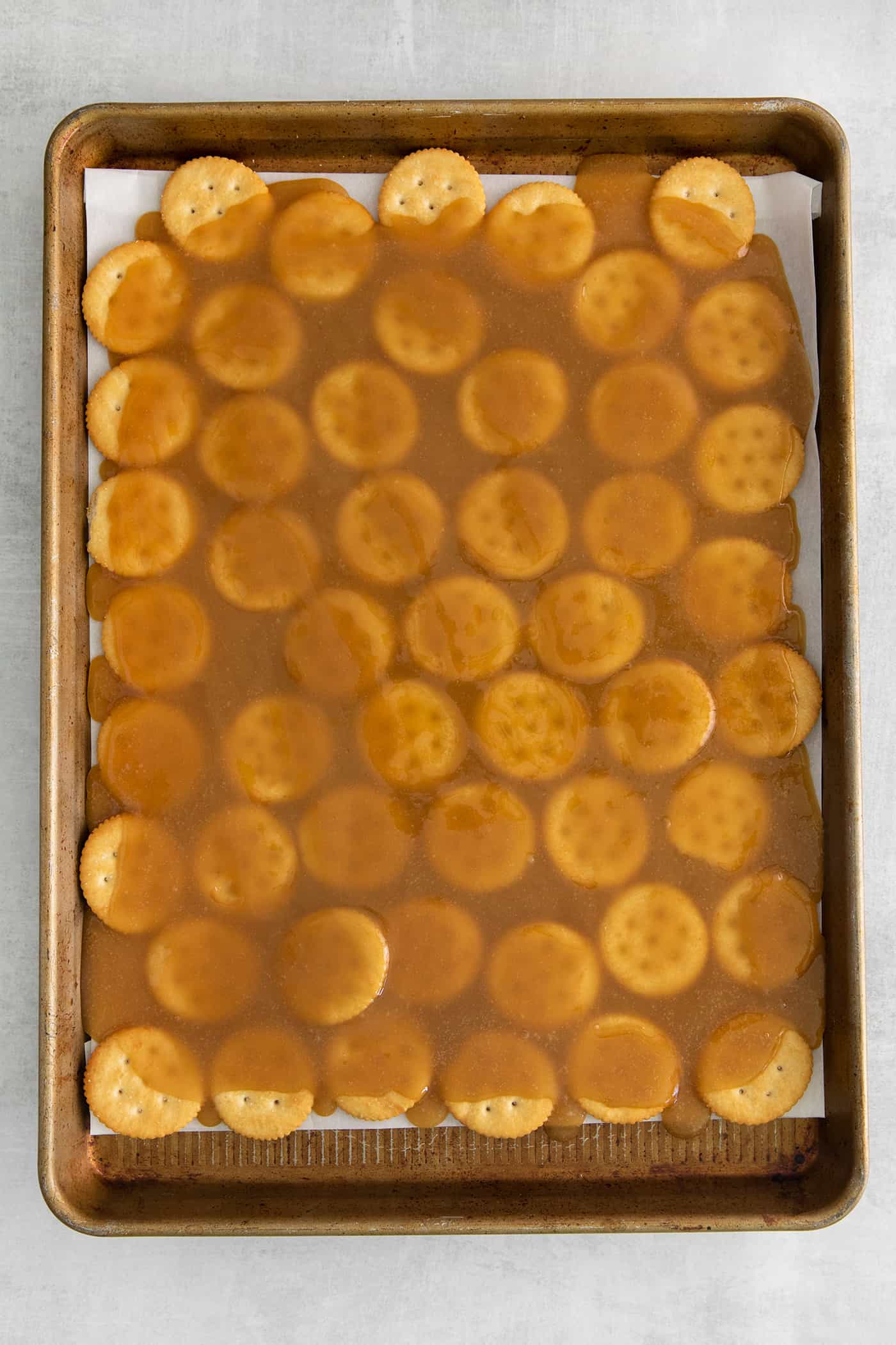 Ritz crackers topped with caramel on a baking sheet