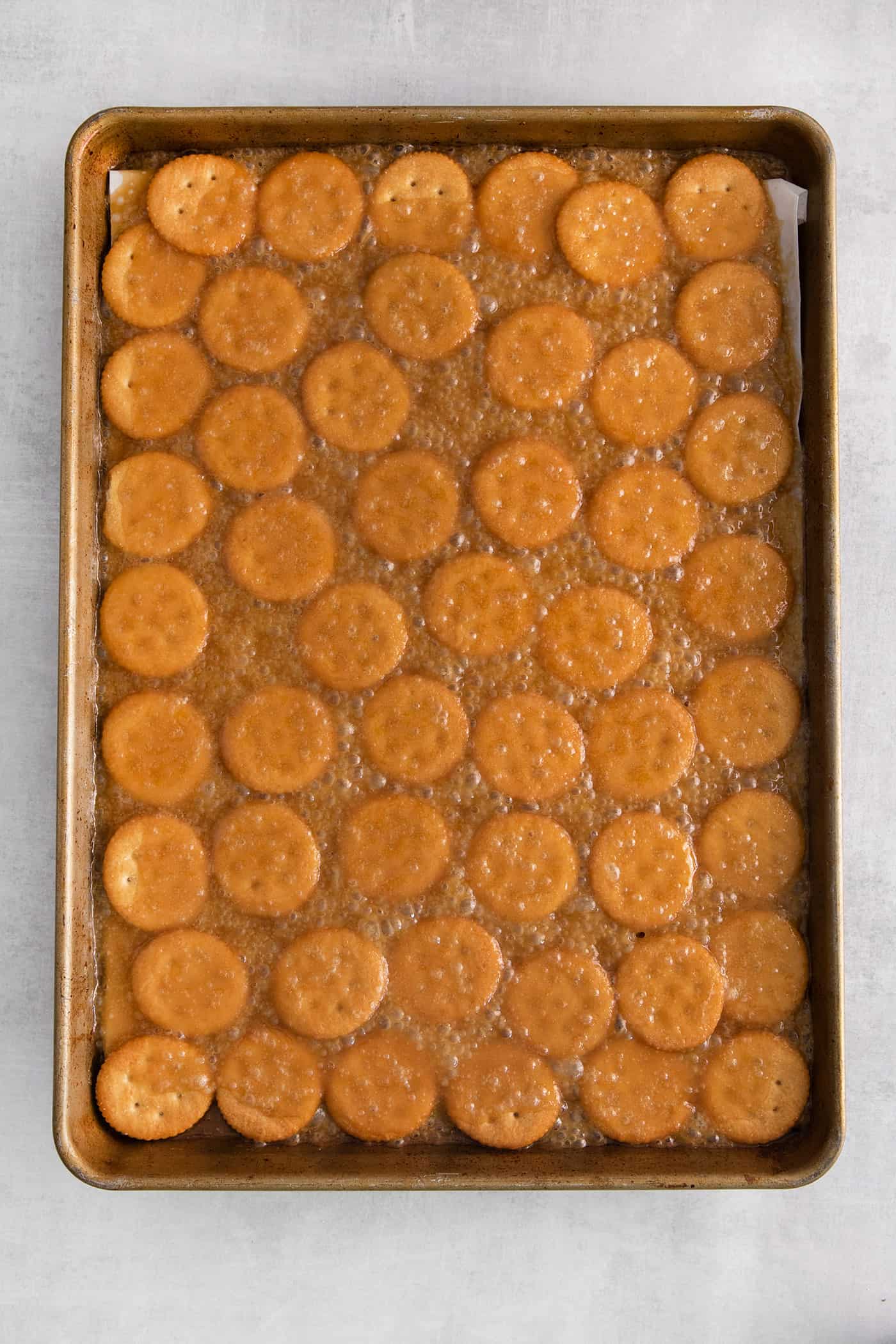 Ritz crackers topped with caramel on a baking sheet