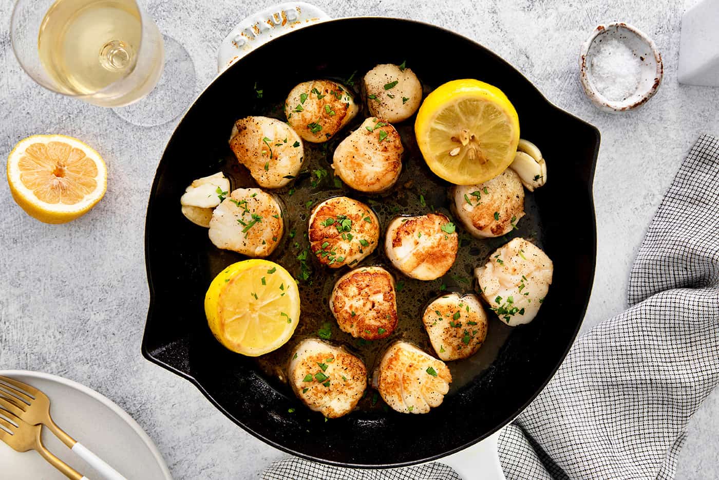Overhead view of seared scallops in a skillet