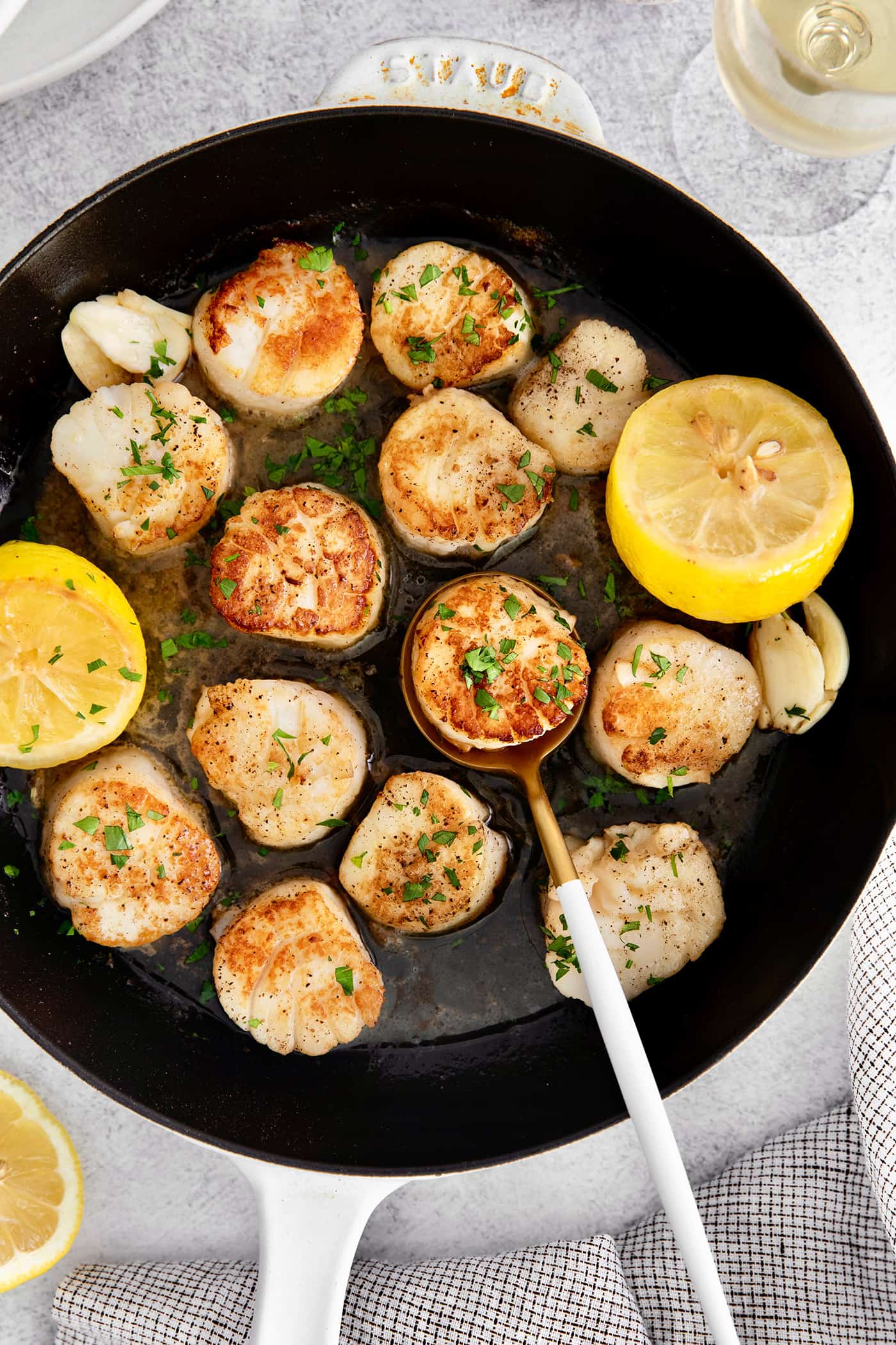 Overhead view of seared scallops in a skillet