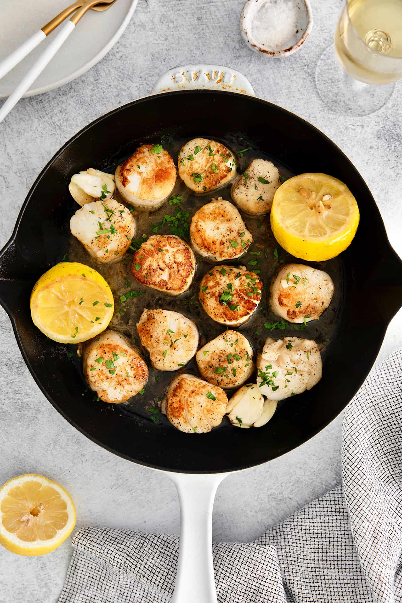 Seared scallops in a cast iron skillet with lemon