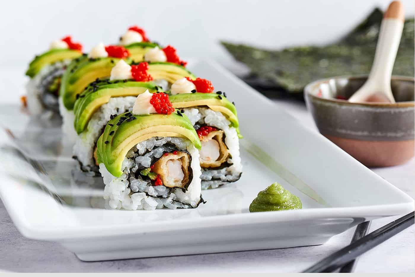 A sushi roll with shrimp tempura and avocado.