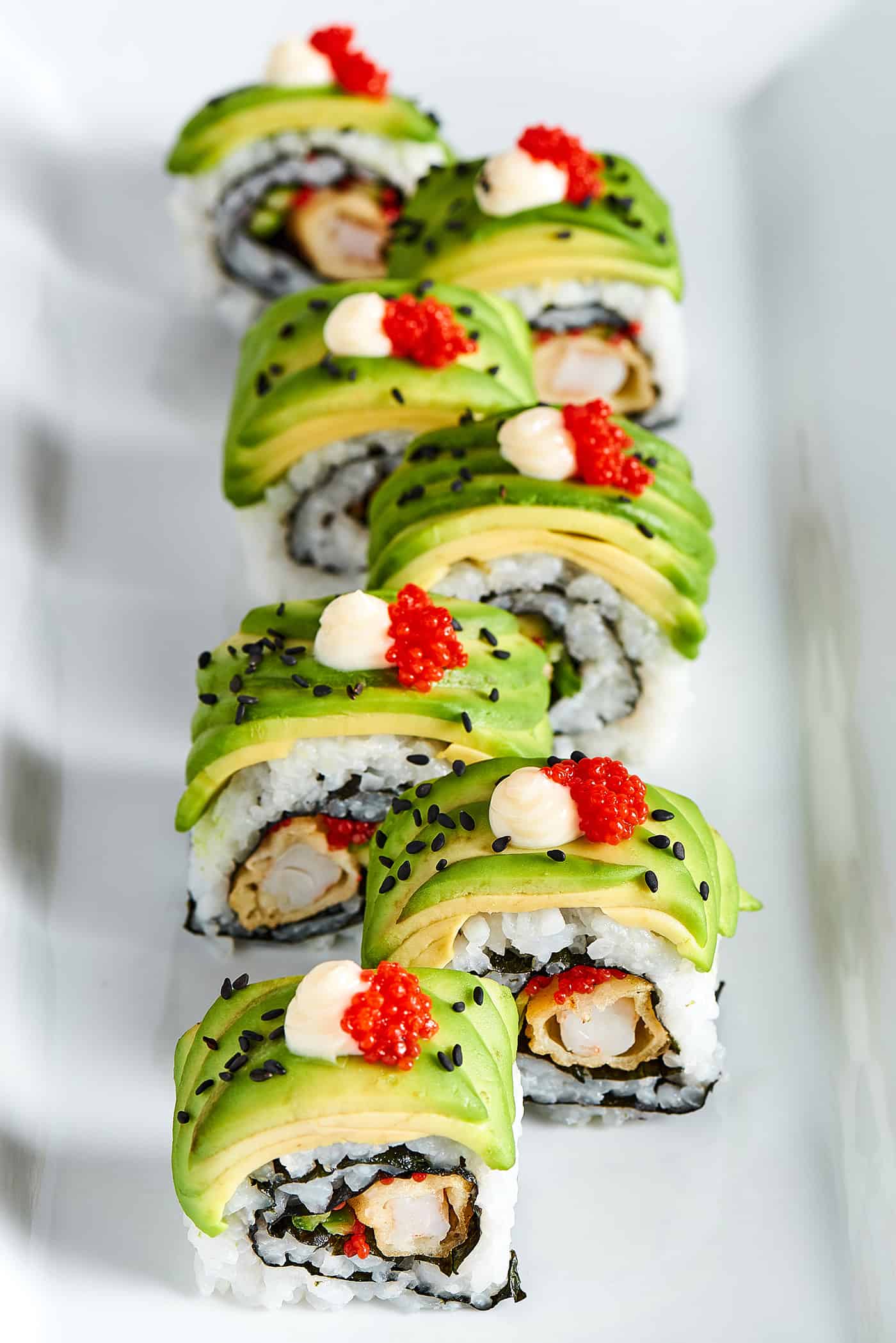 Overhead photo of sushi roll topped with thin slices of avocado.