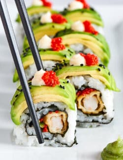 chopsticks picking up a piece of sushi roll