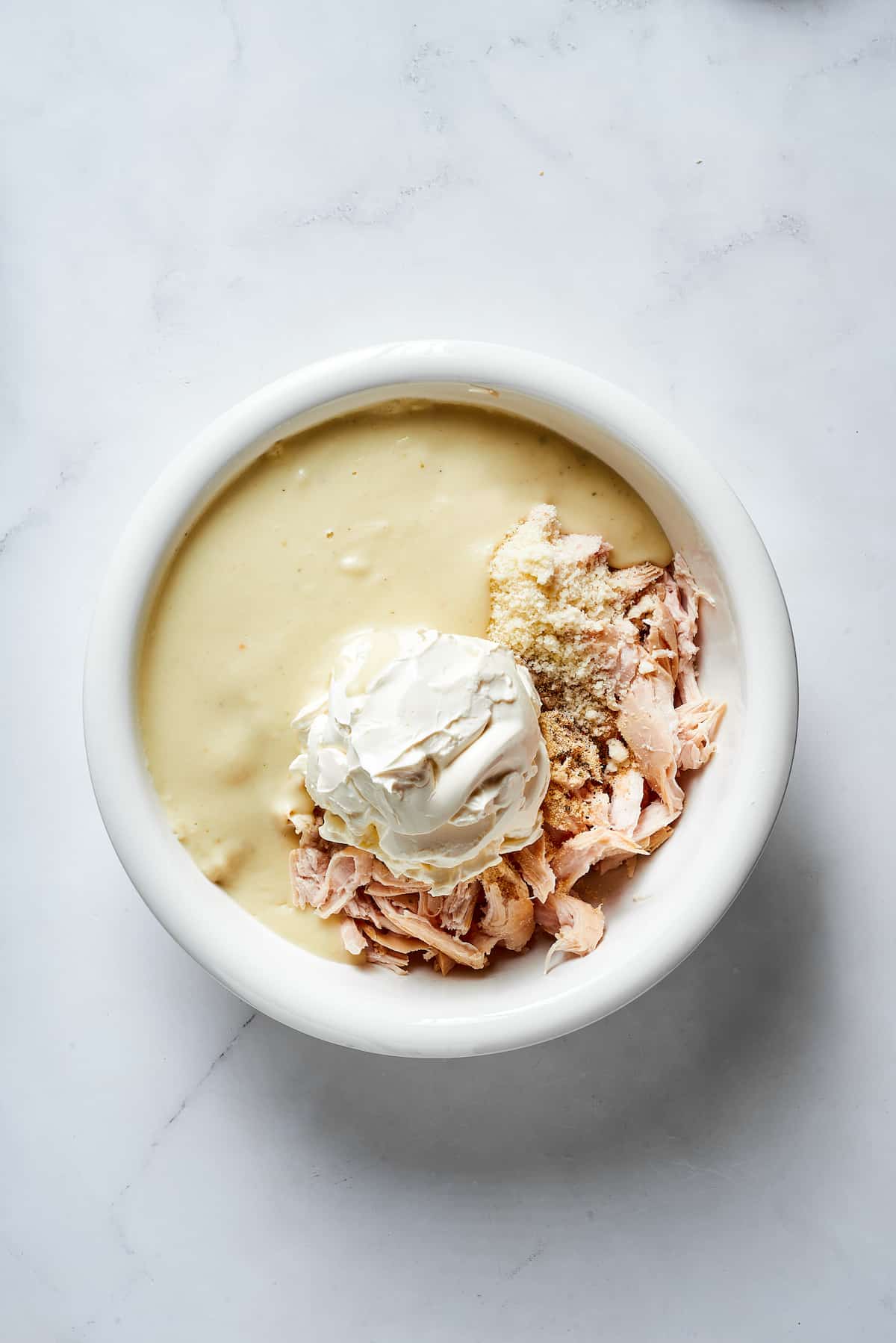 Chicken, cream of chicken soup, and cream cheese in a bowl