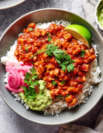 sofritas in a rice bowl with guacamole and pickled red onions