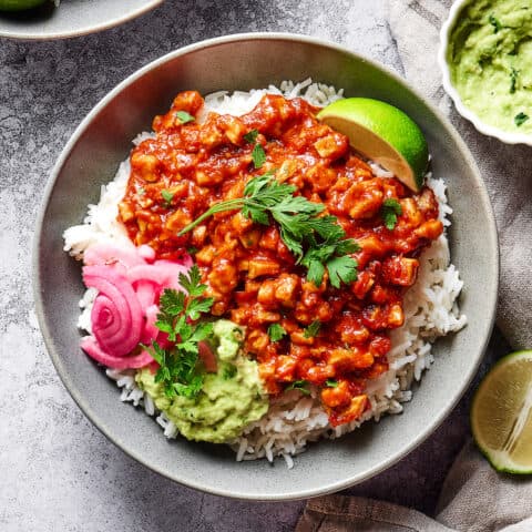 sofritas in a rice bowl with guacamole and pickled red onions