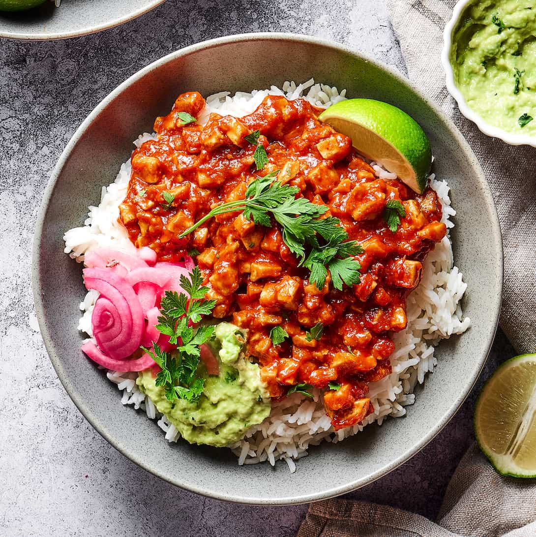 sofritas in a rice bowl with guacamole and pickled red onions