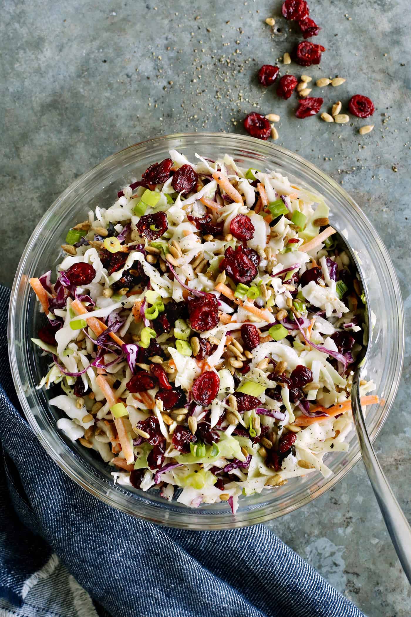 Made with a creamy, tangy dressing, dried cranberries, and sunflower kernels, this Cranberry Coleslaw is an easy side for any occasion. Overhead view of a bowl of cranberry coleslaw
