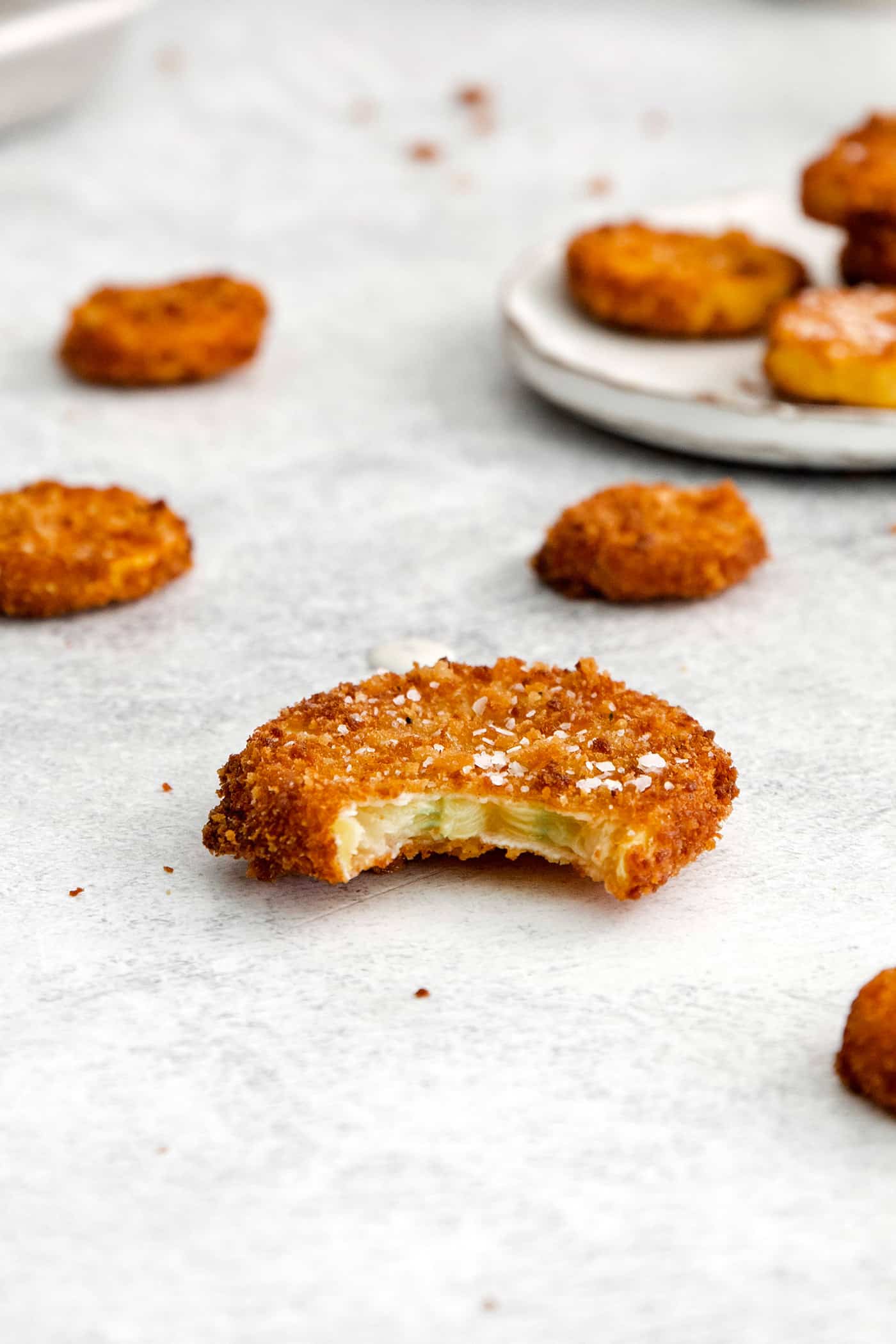 A fried squash round with a bite missing