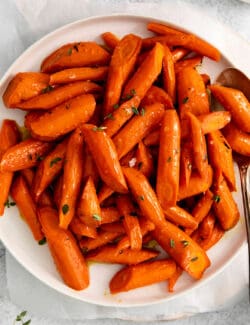 Overhead view of honey garlic carrots on a white plate