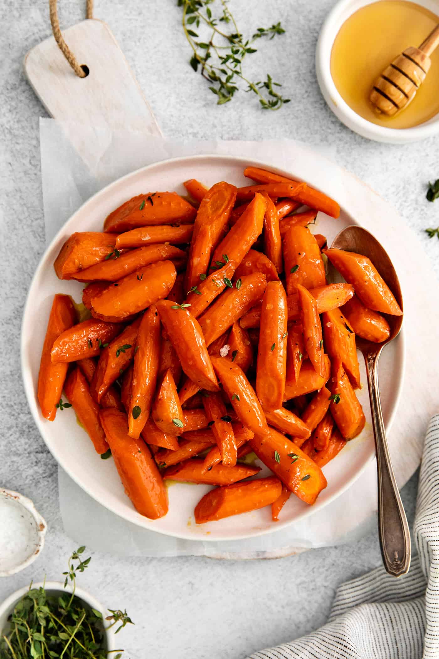 These Honey Garlic Carrots are the perfect side dish – impressive enough for holidays and easy enough for every day! Ready in 30 minutes! overhead view of honey garlic carrots on a white plate
