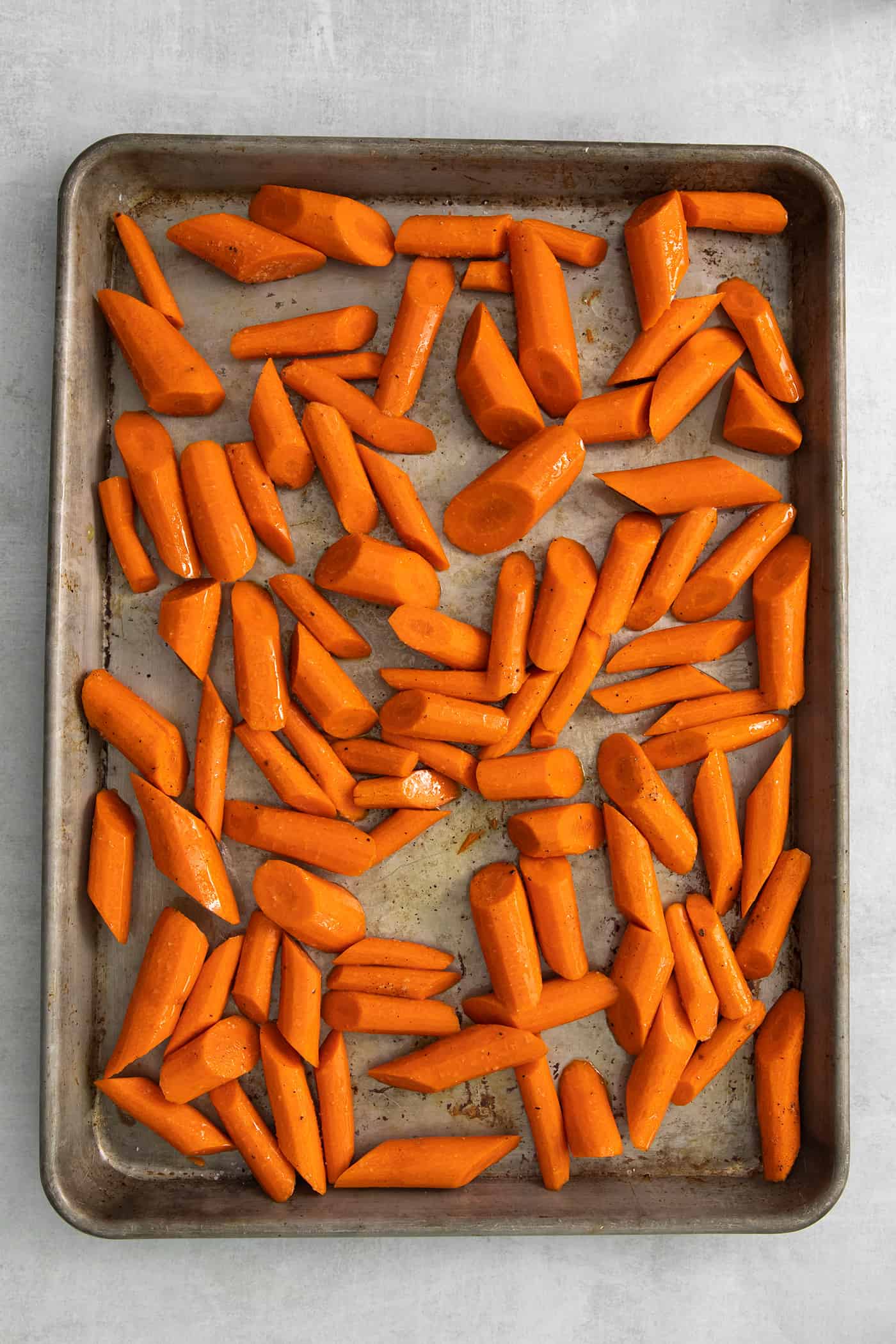 Pieces of carrots spread on a baking sheet