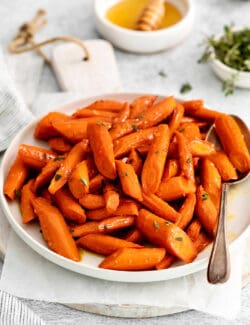Angled view of honey garlic carrots on a white plate
