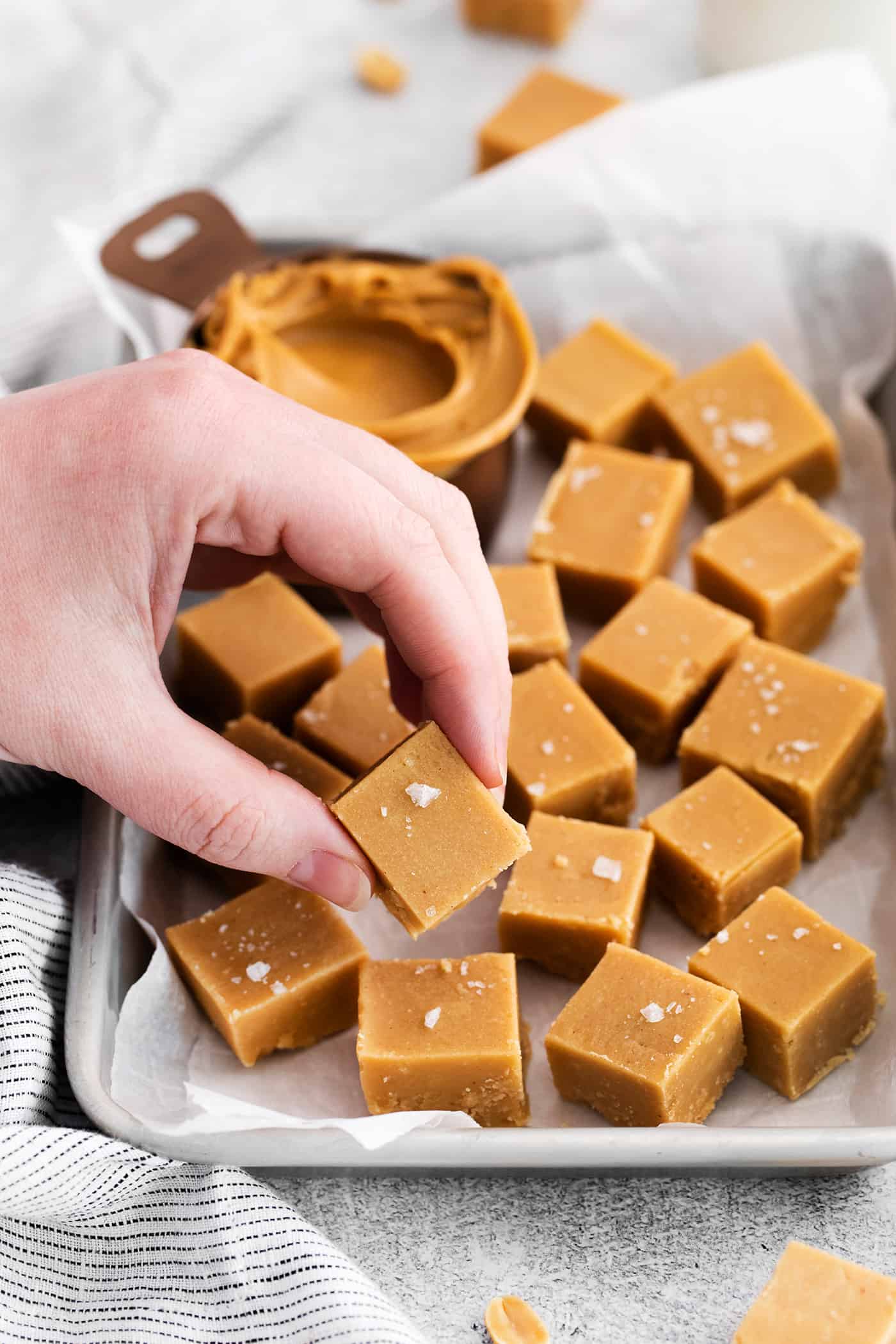 A hand holding a piece of homemade peanut butter fudge