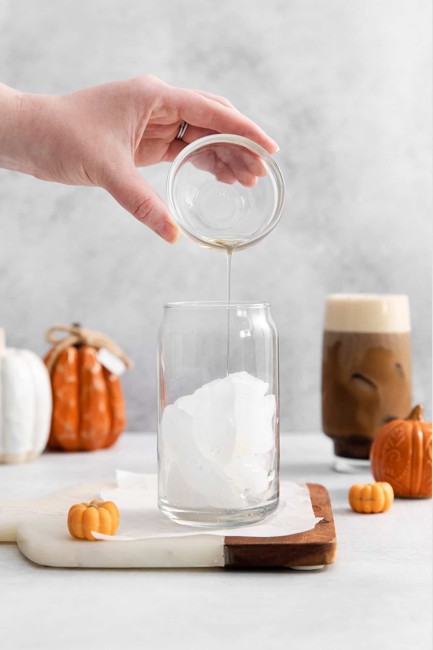 A hand pouring liquid sugar into a glass