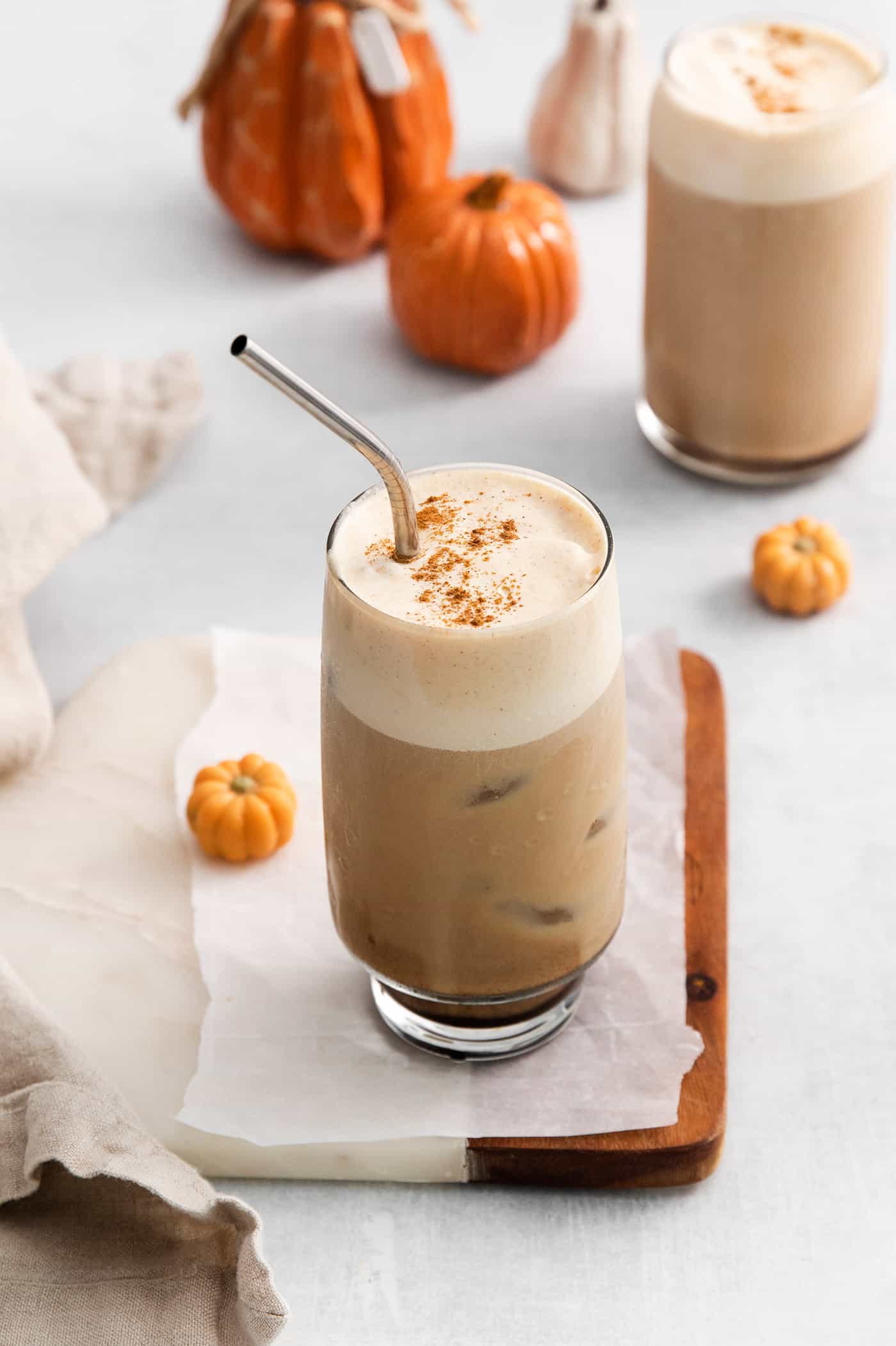 Angled view of a pumpkin cream cold brew with a metal straw