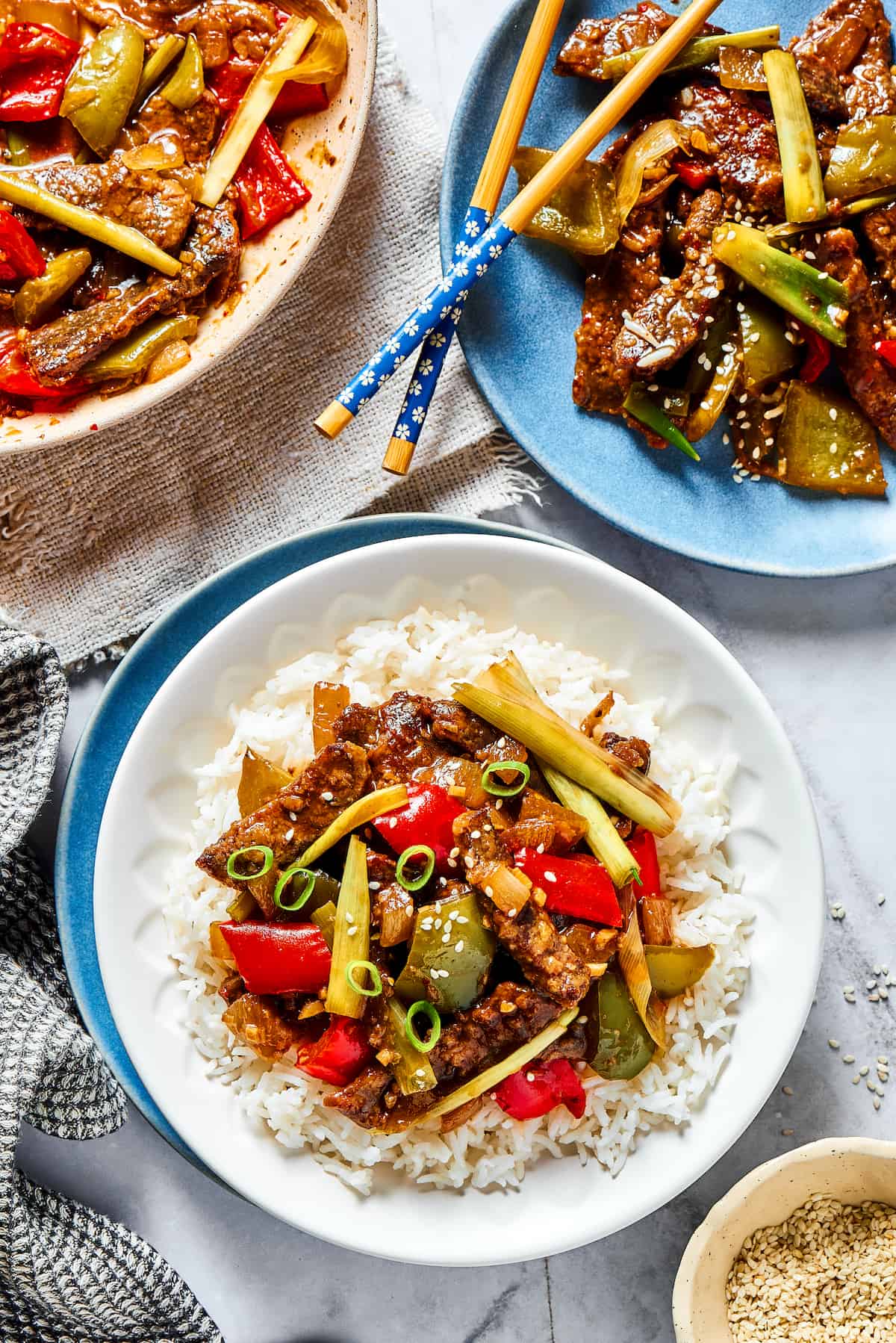 This Easy Hunan Beef recipe is better than take-out! Made with strips of steak, peppers, and onions in a savory, mildly hot, and tangy sauce. Overhead view of a plate of hunan beef