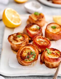 Bacon wrapped scallops on a white platter