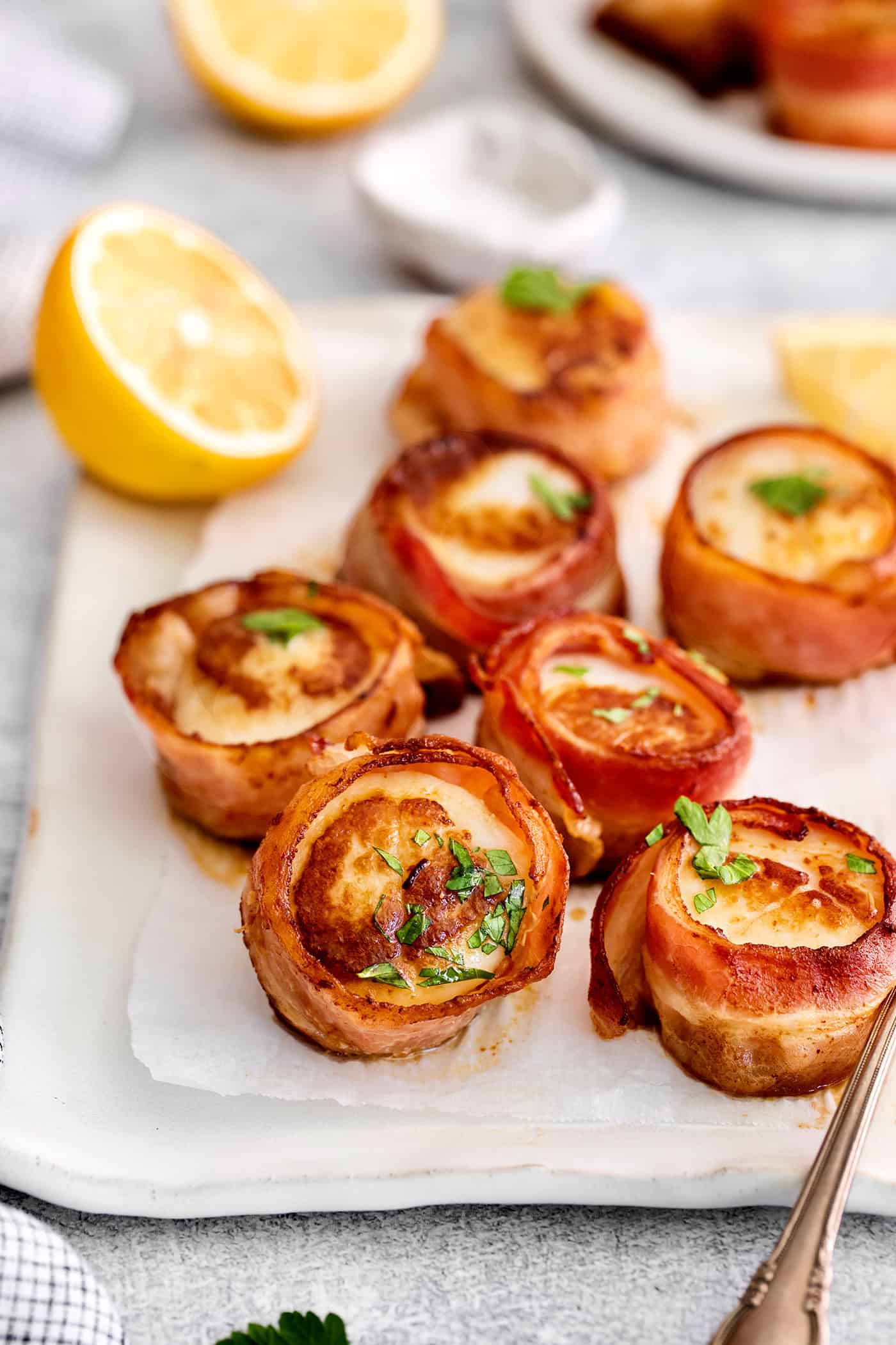 Bacon wrapped scallops on a white platter