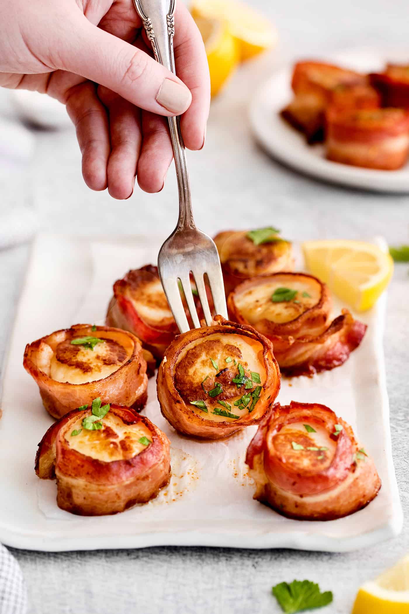 A fork grabbing a bacon wrapped scallop