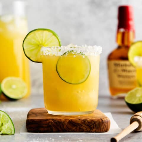 A bourbon margarita on a wooden coaster