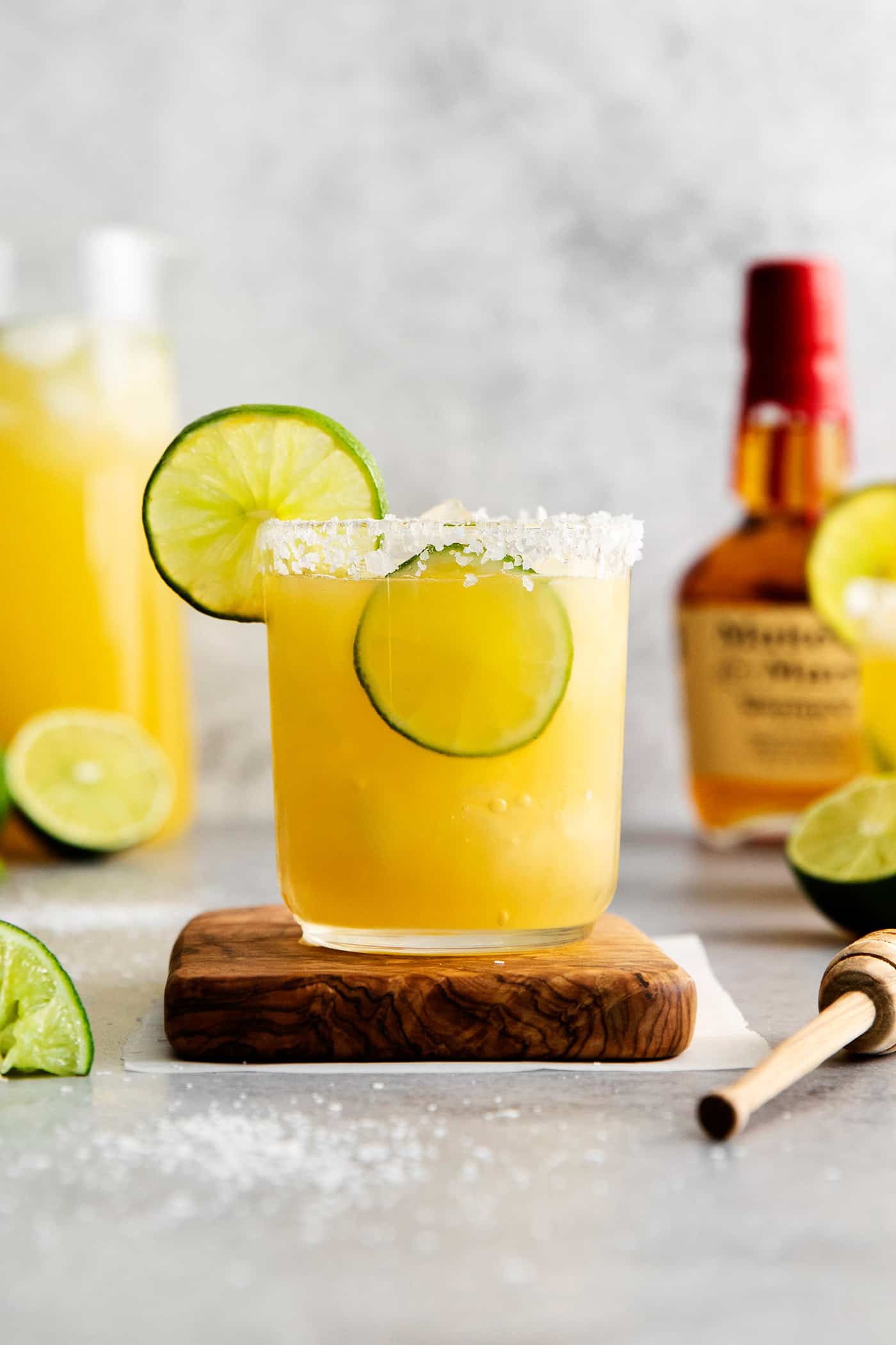 A bourbon margarita on a wooden coaster