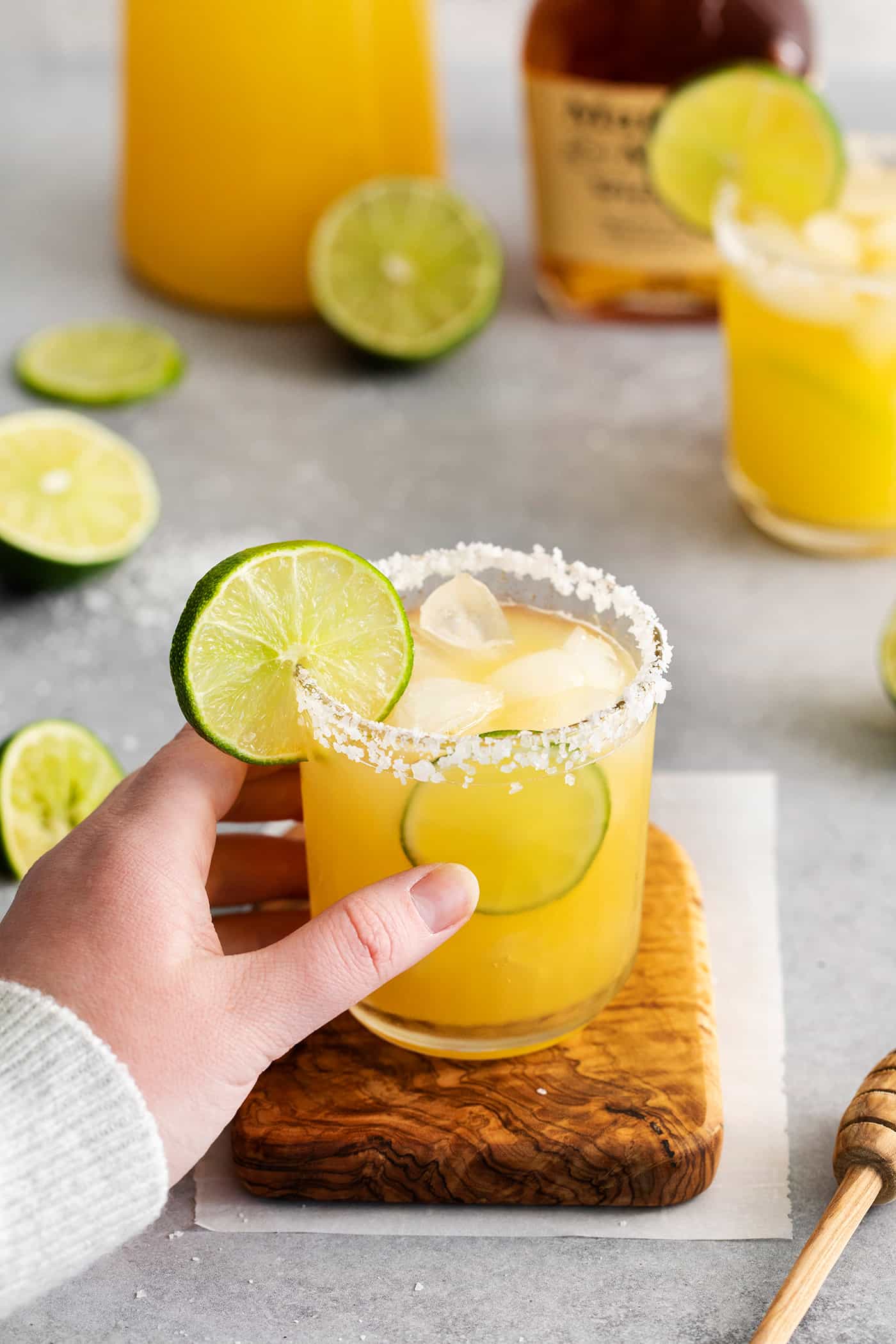 A hand reaching for a whiskey margarita