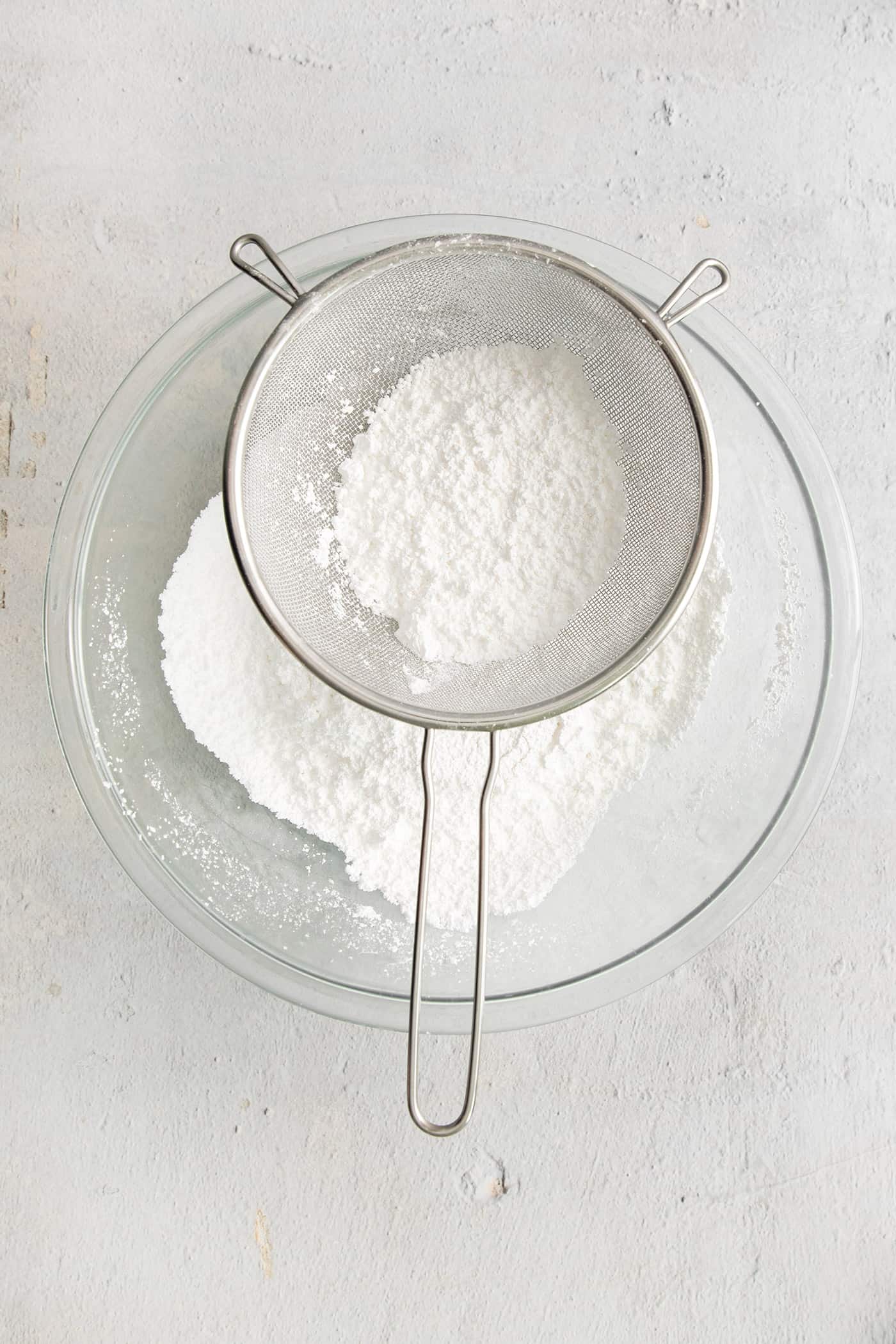 Powdered sugar being sifted into a bowl