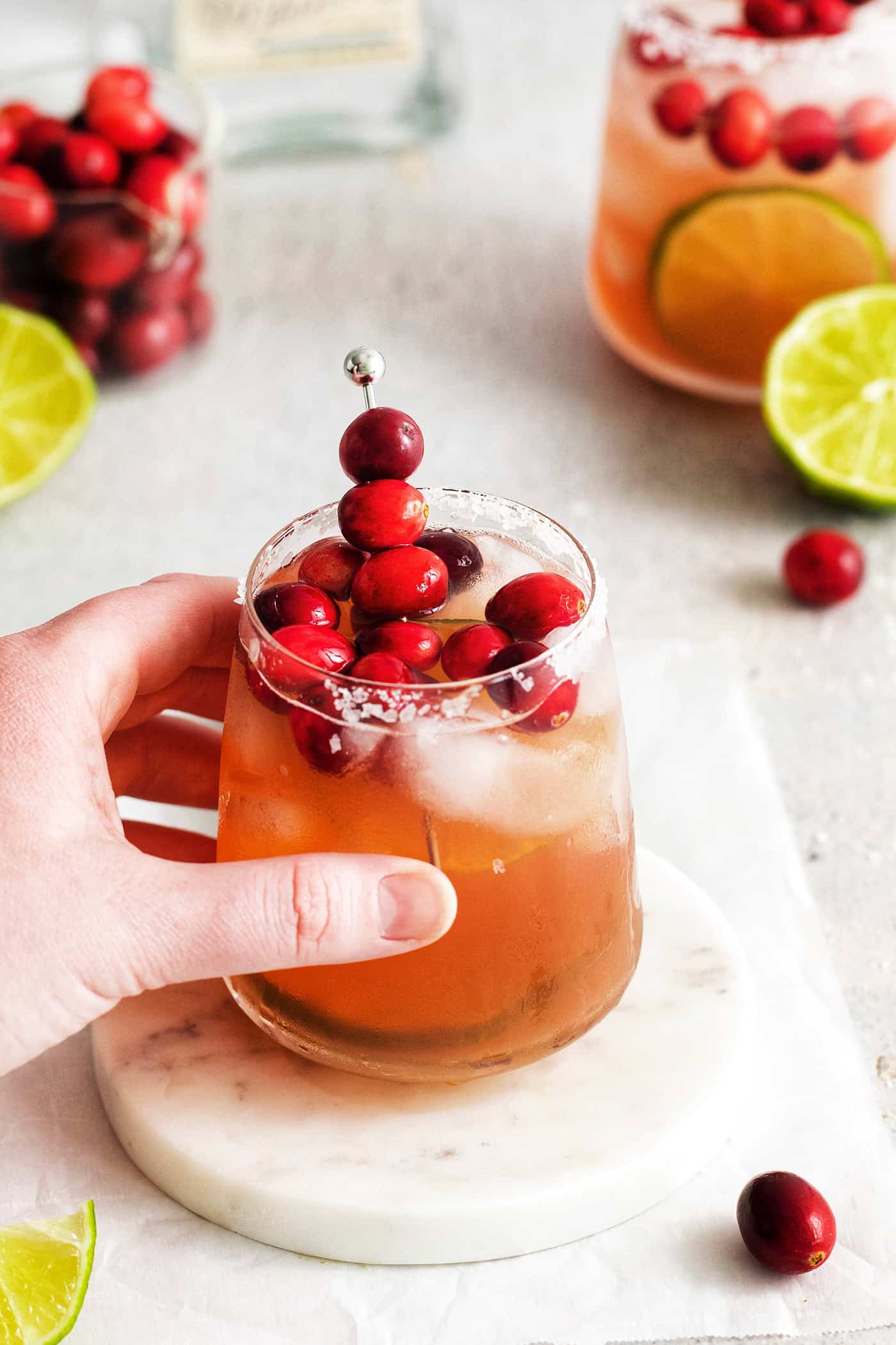 A hand holding a cranberry margarita