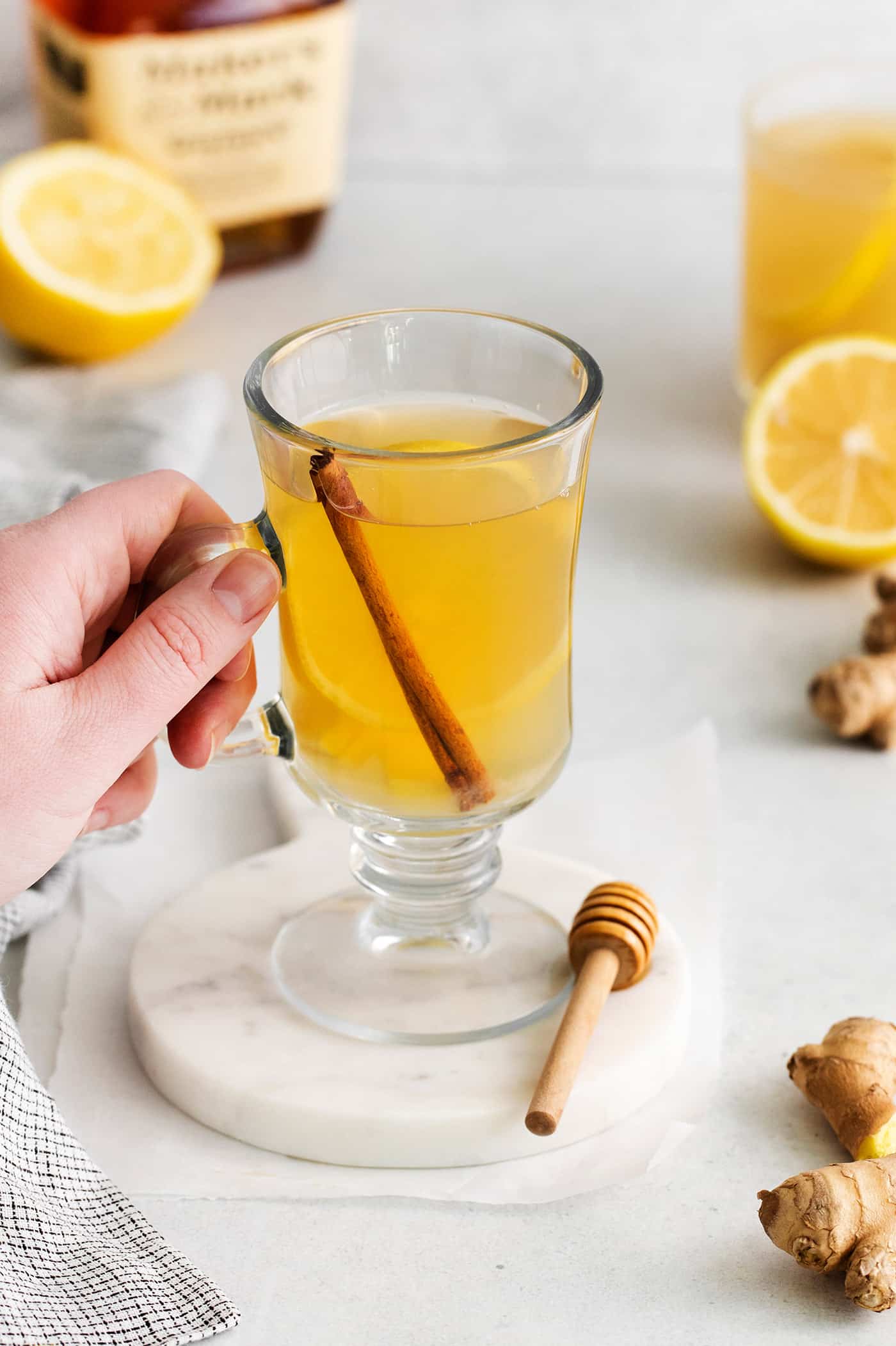 A hand grabbing a glass mug