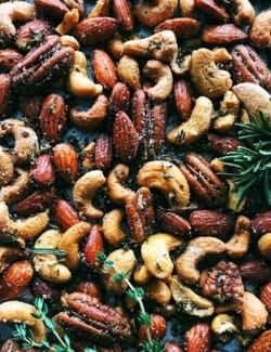 Close-up of my spiced nuts recipe with fresh rosemary and thyme.