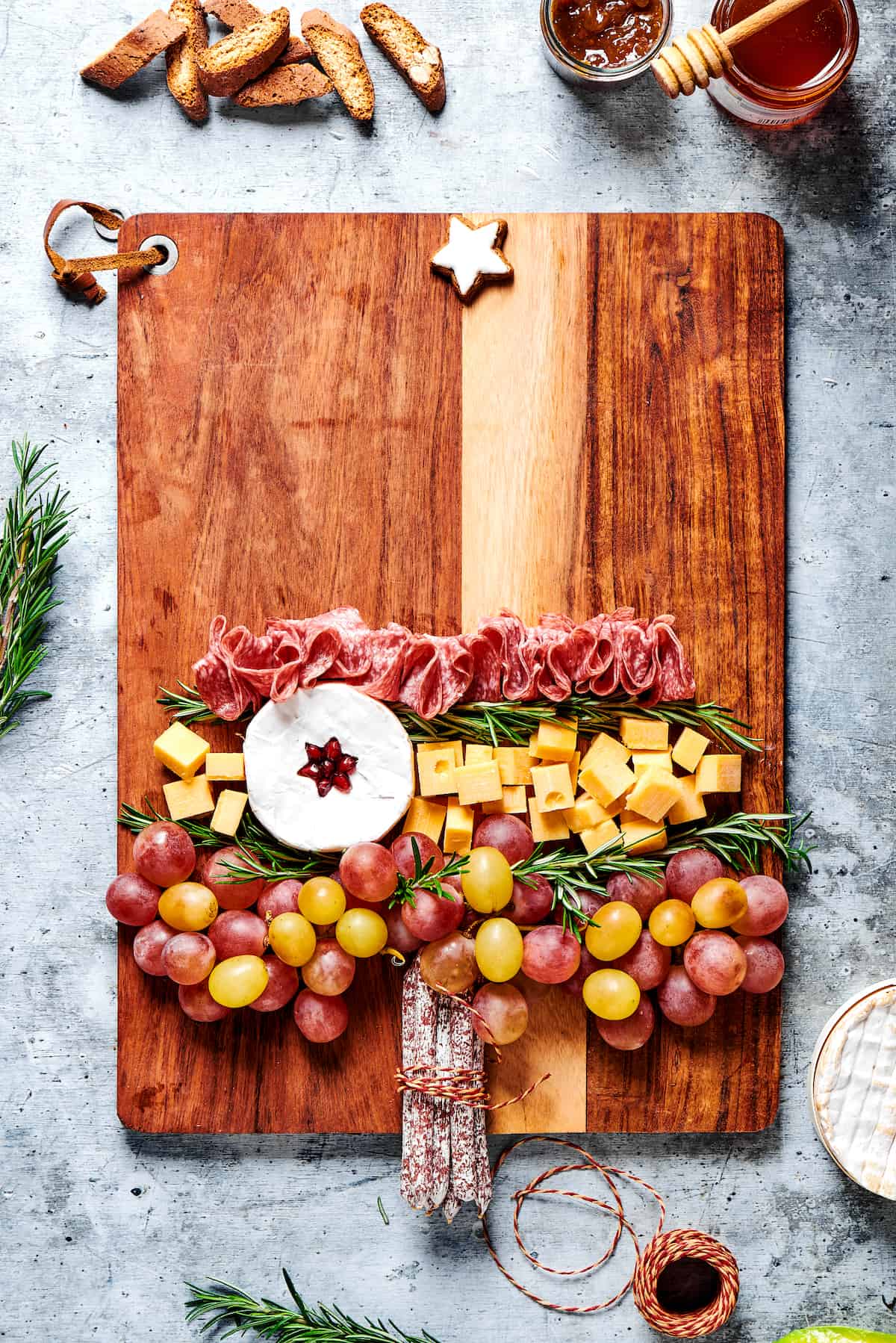 The bottom half of a charcuterie board with grapes, cheese, and salami