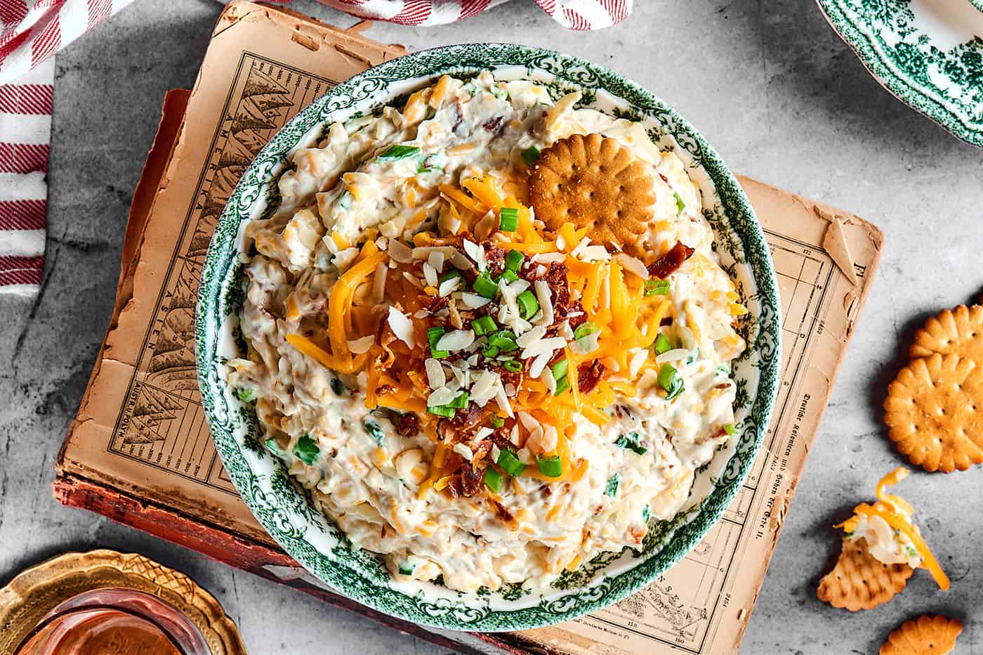 neiman marcus cheese dip in a bowl, plus crackers and a drink