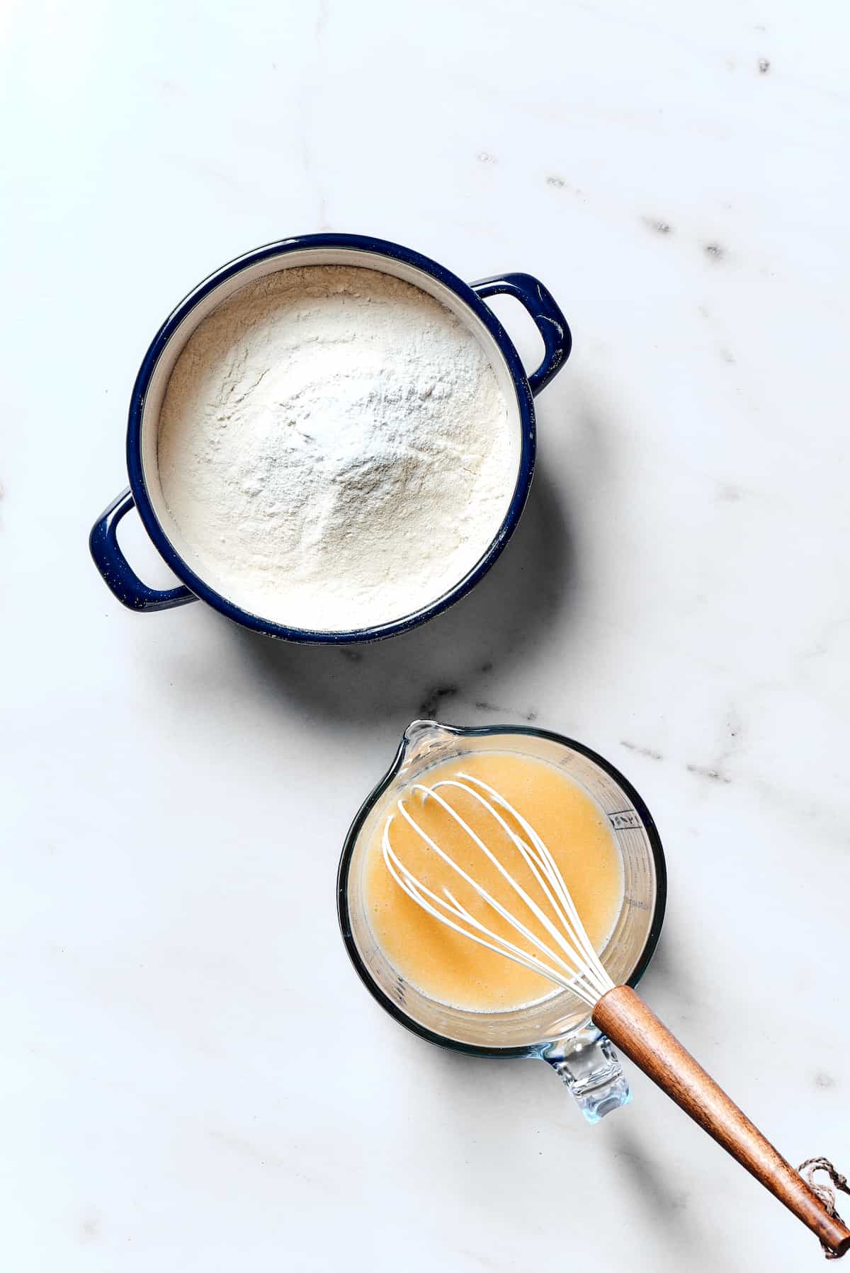 Flour in a pot and a whisked egg in a small bowl