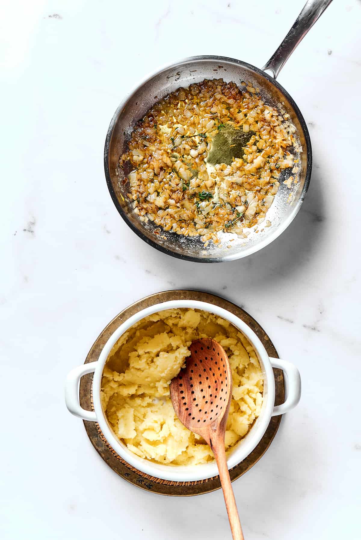 Mashed potatoes in a bowl and sauteed onions in a pan