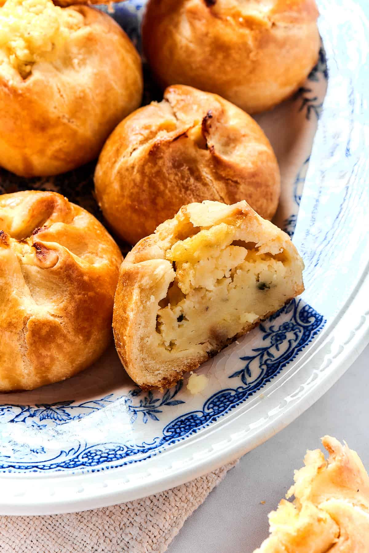 A corner of a plate of knish, with one cut in half