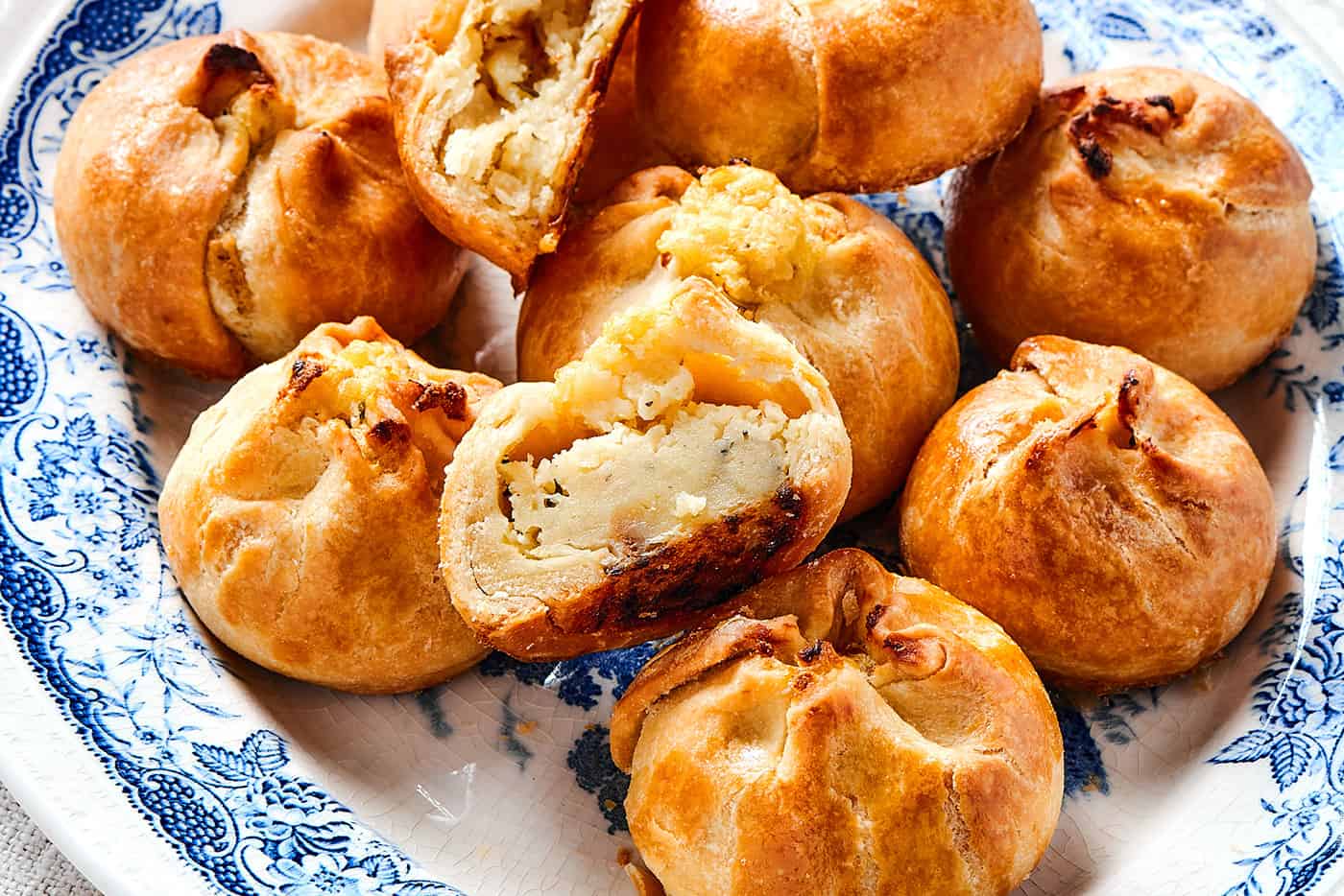 potato knishes on a platter, with one cut in half