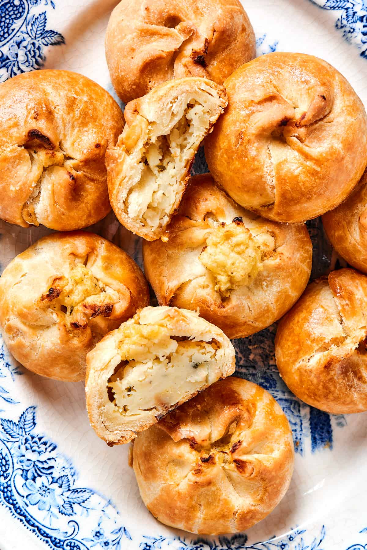 Overhead view of a plate of knish, with one cut in half