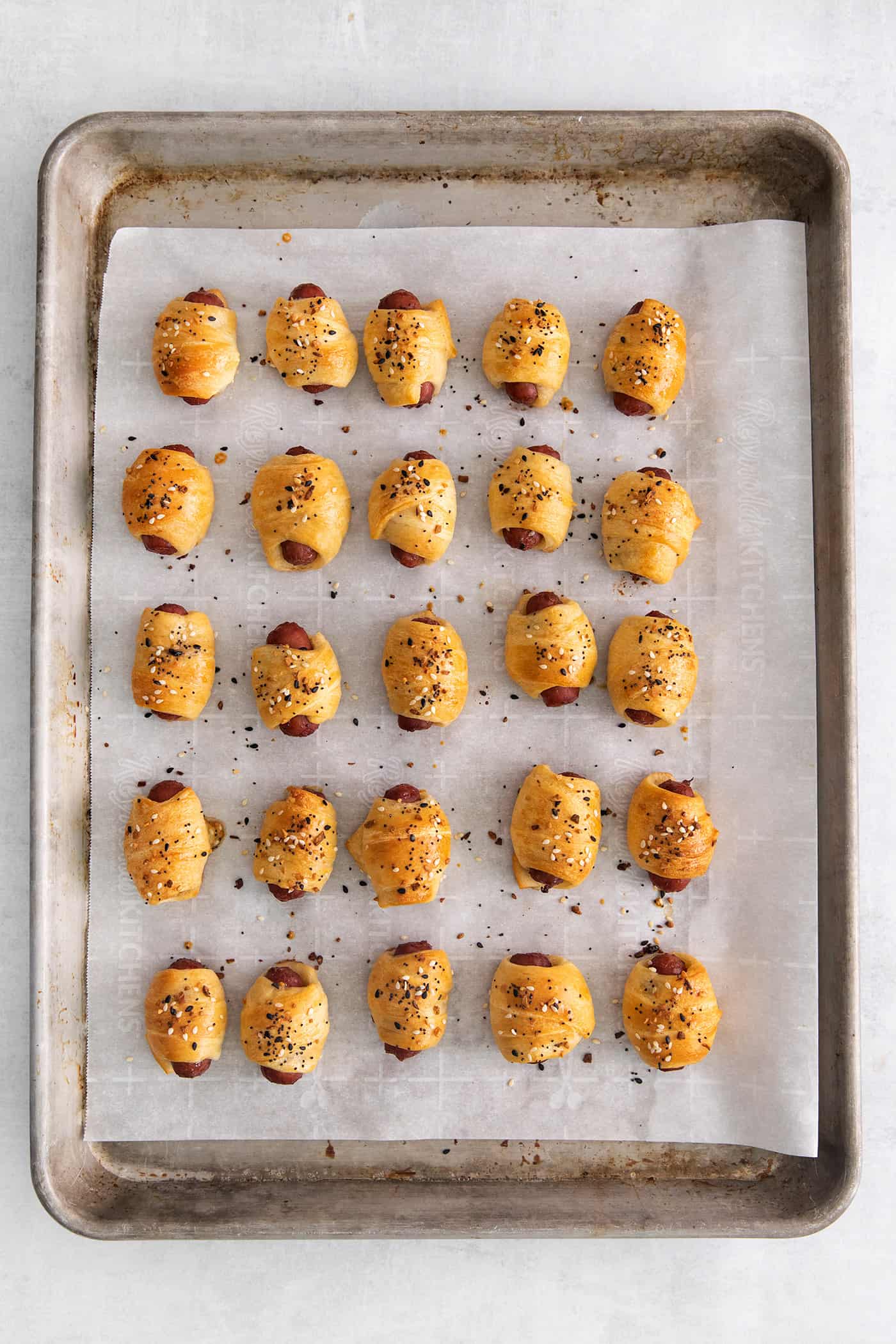 Mini pigs in a blanket on a baking sheet