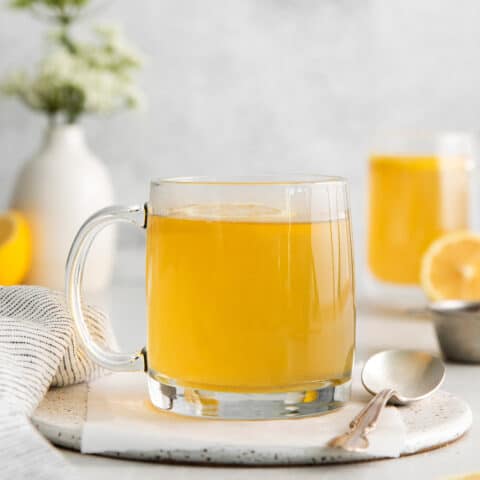 A clear mug of honey citrus mint tea