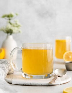 A clear mug of honey citrus mint tea